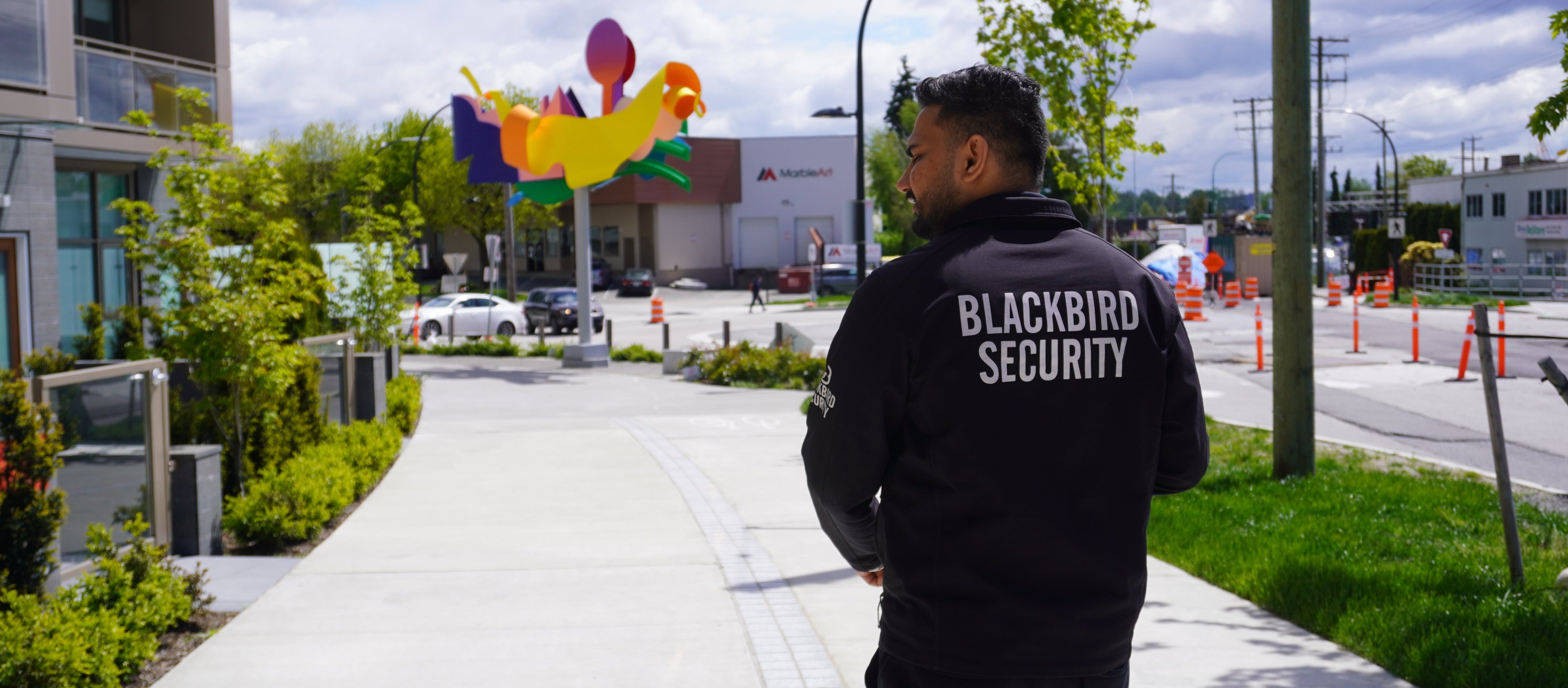 A condominium security guard patrols the sidewalk along the perimeter of a property