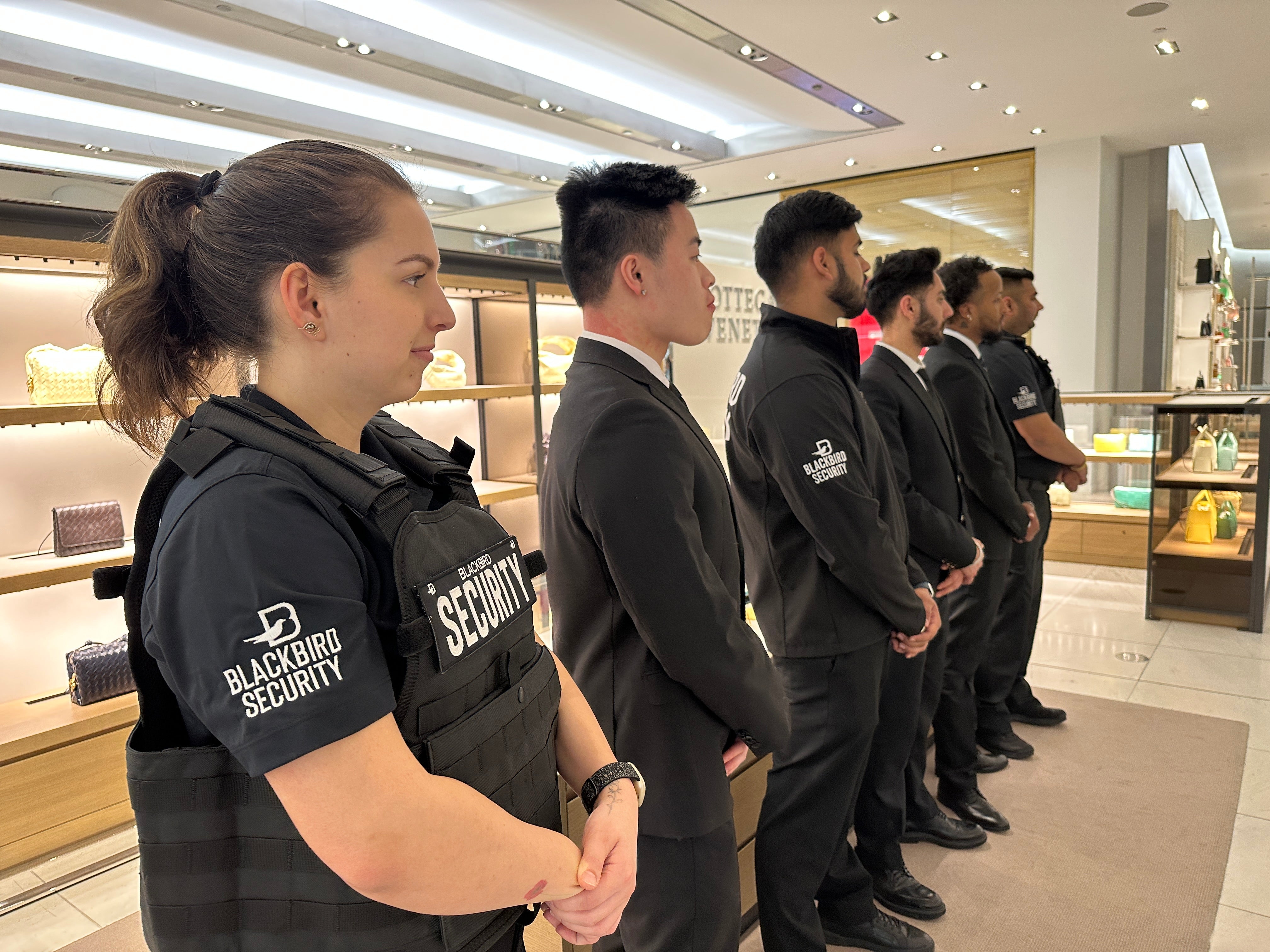 Uniformed and Plained Clothes Blackbird security guards standing in a line at a retail location
