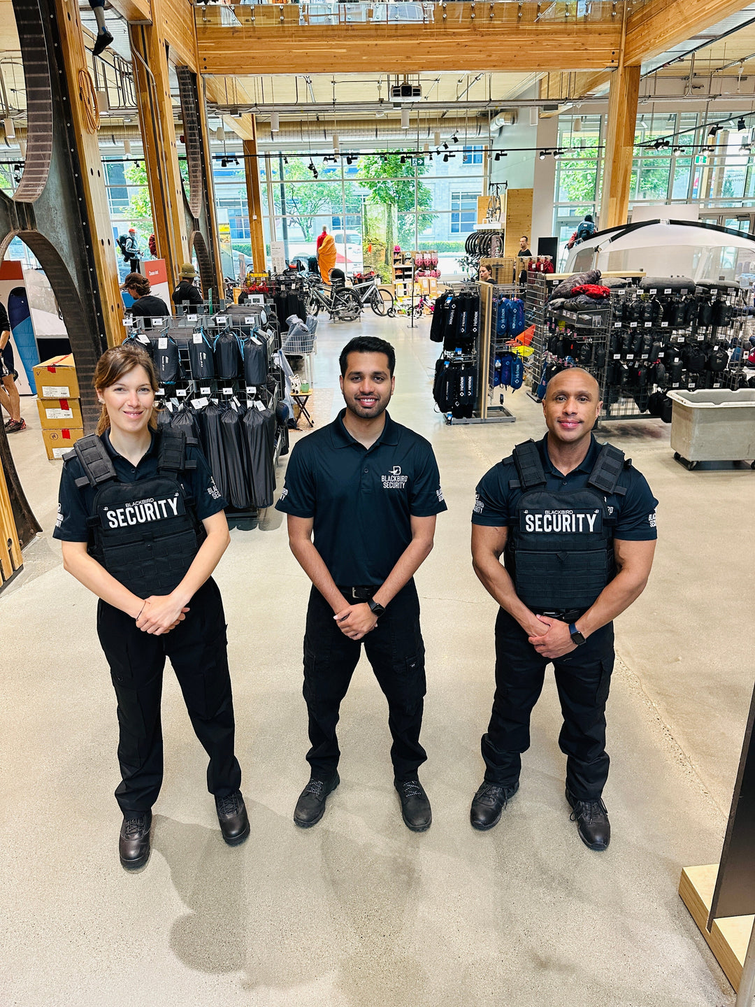 Three Uniformed Blackbird security guards standing in retail location