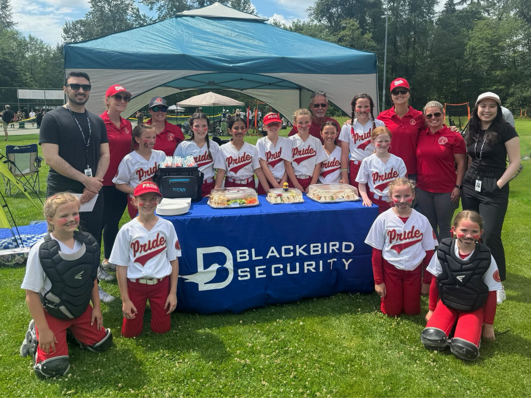 kids baseball team sitting in front of blackbird security branded table
