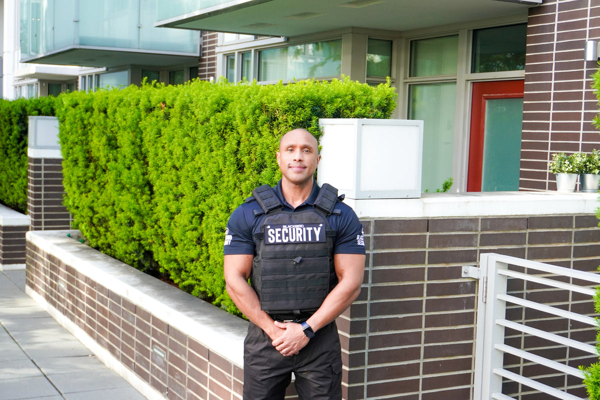 Blackbird security guard stands outside of a community building