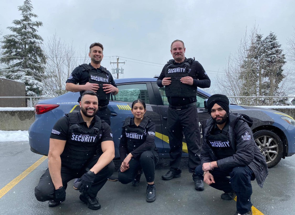 Five Uniformed Blackbird security guards in front of Mobile patrol car