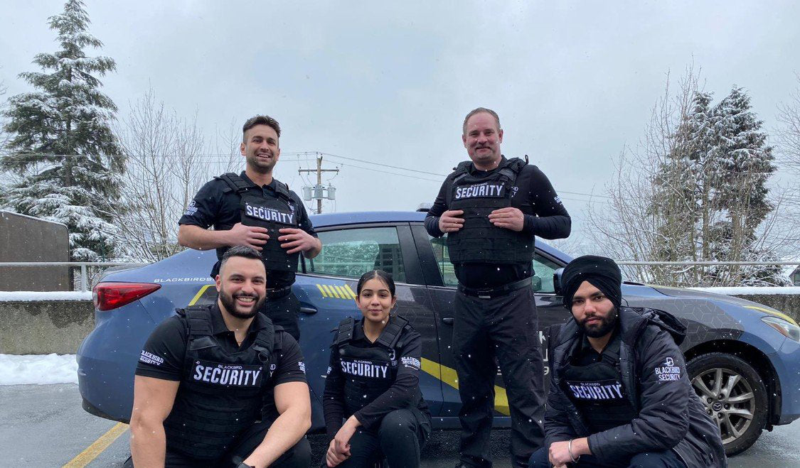 Five Uniformed Blackbird security guards in front of Mobile patrol car