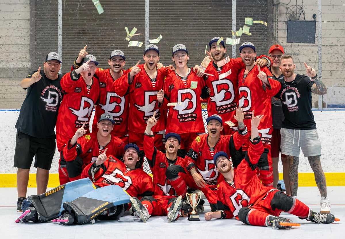 A group of hockey players sitting on ice throwing money in the air
