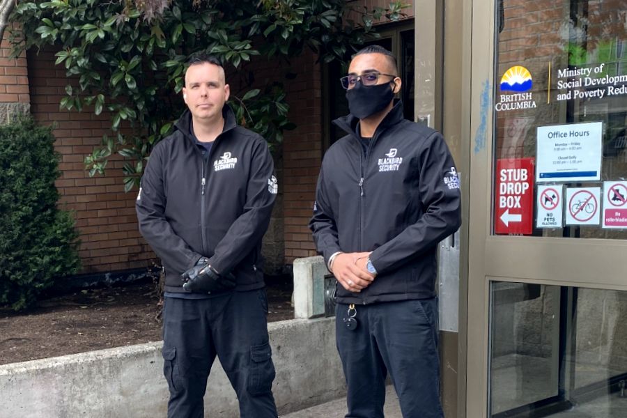 Two Uniformed Blackbird security guards standing in front of building