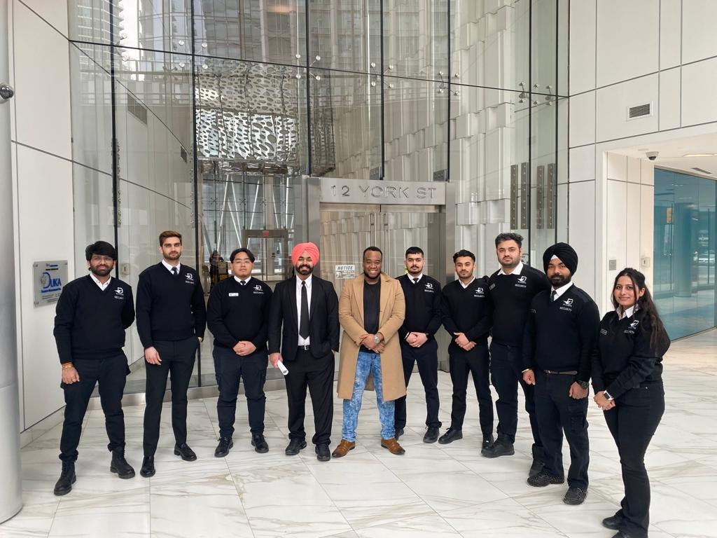 Nine Uniformed Blackbird security guards standing in front condo lobby