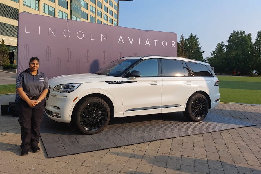 Security officers guarding a Lincoln Aviator vehicle at an event.