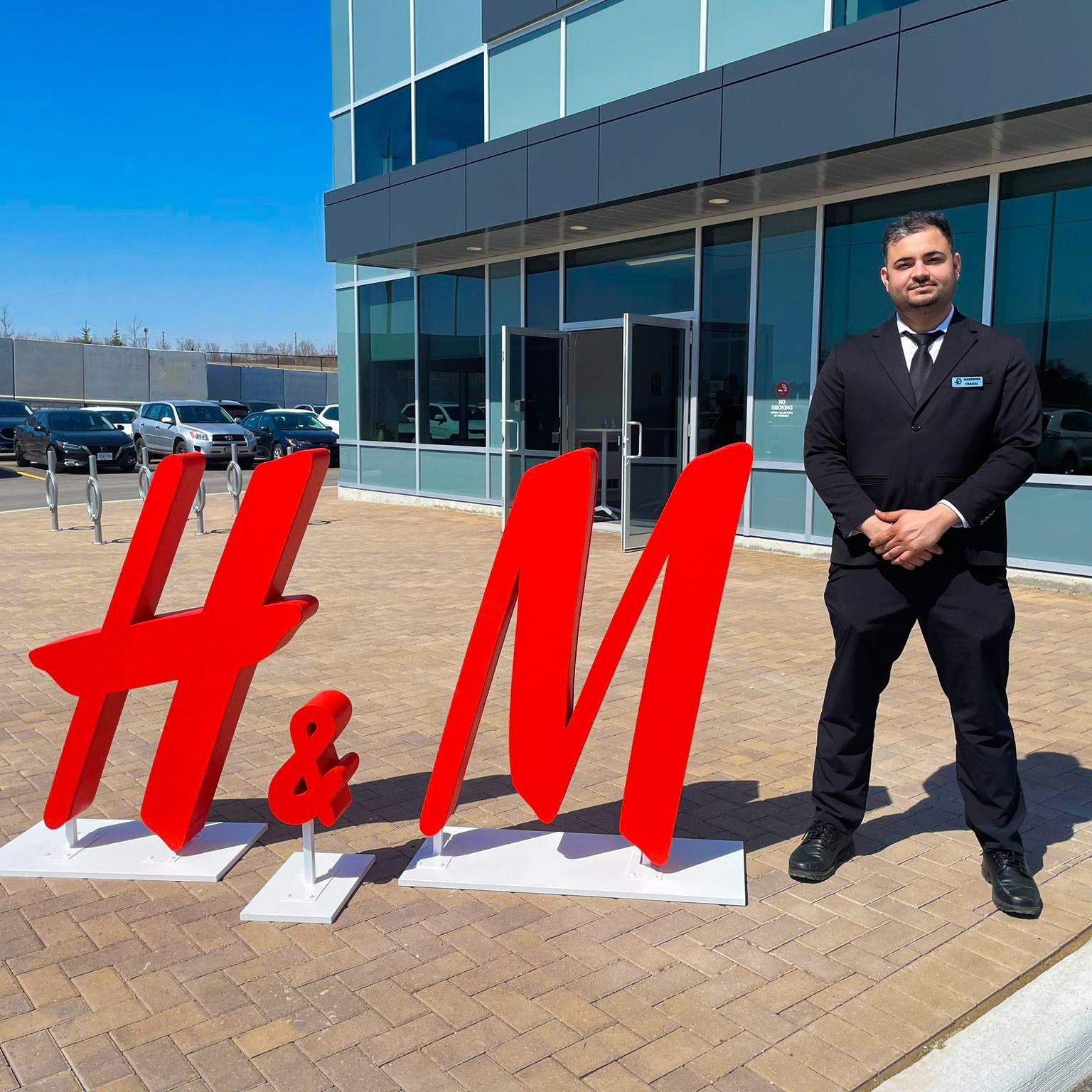 Uniformed Blackbird security guard standing in front of H&M sign