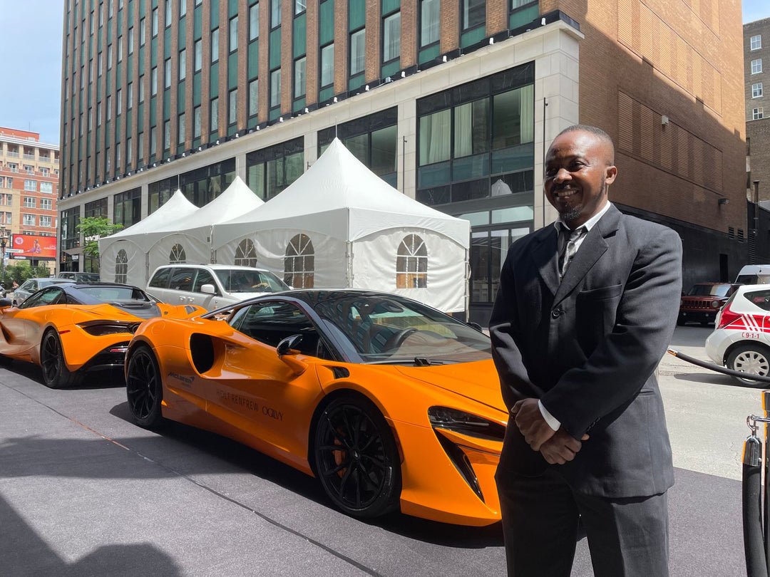 Plained Clothes Blackbird security guard standing in front of two mcclaren cars