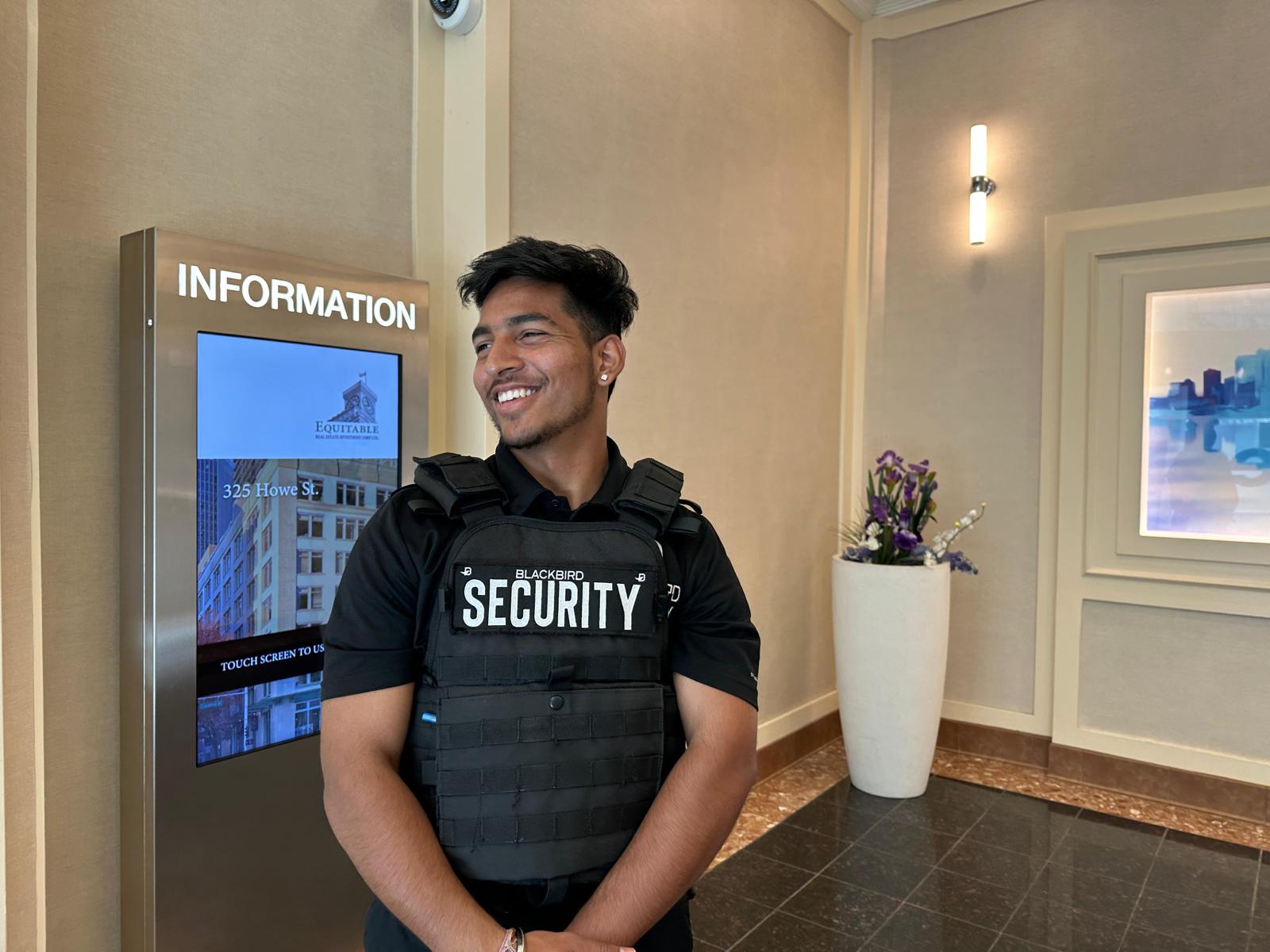 Blackbird security guard in front of information screen in residential complex
