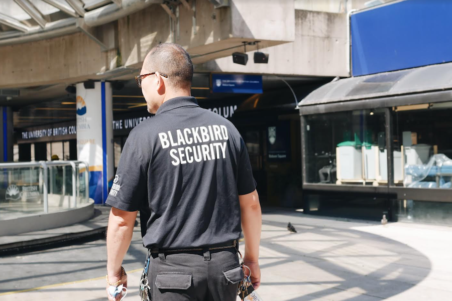 A security guard in front of a university campus