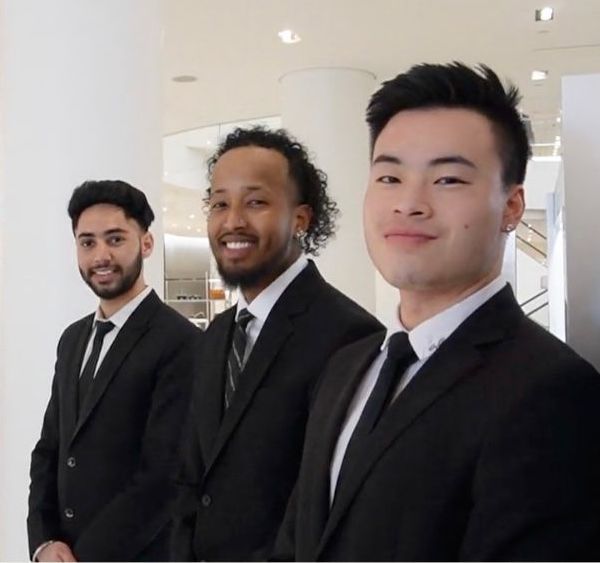 Three suit and tie security officers standing together in a retail store in the Maritimes.