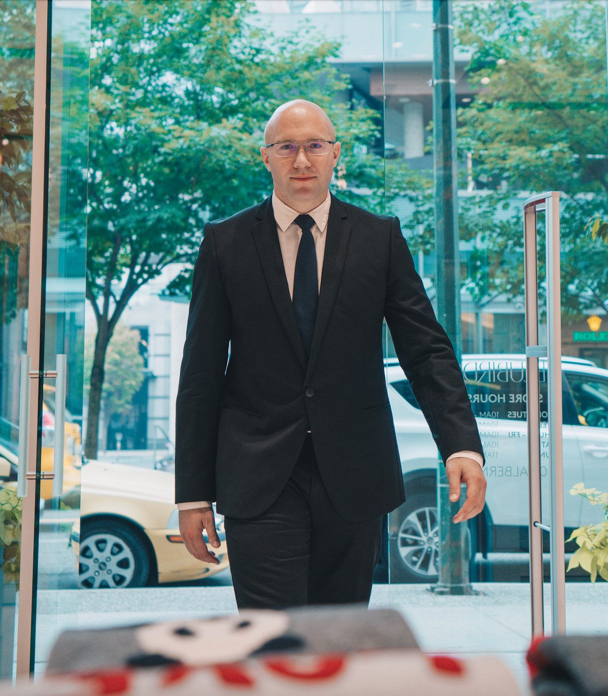 Security guard in suit and tie walking through glass door with anti theft scanner