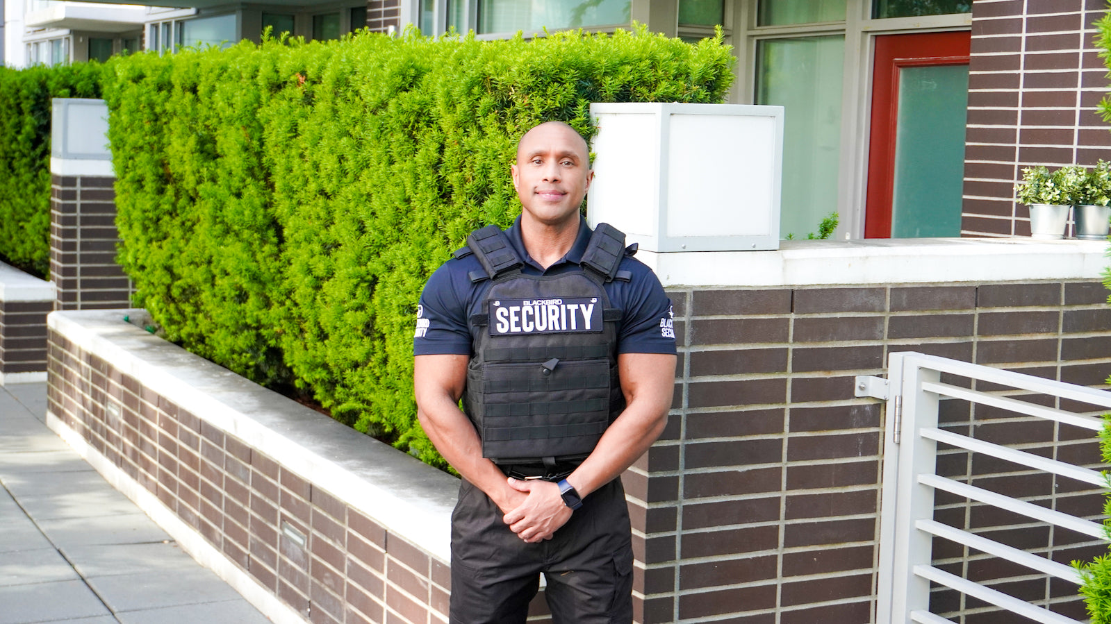 Blackbird security guard stands outside of a community building